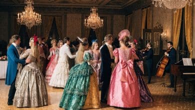 Salão de baile inspirado em Bridgerton, com figurinos de época coloridos, lustres brilhantes e músicos tocando instrumentos de cordas